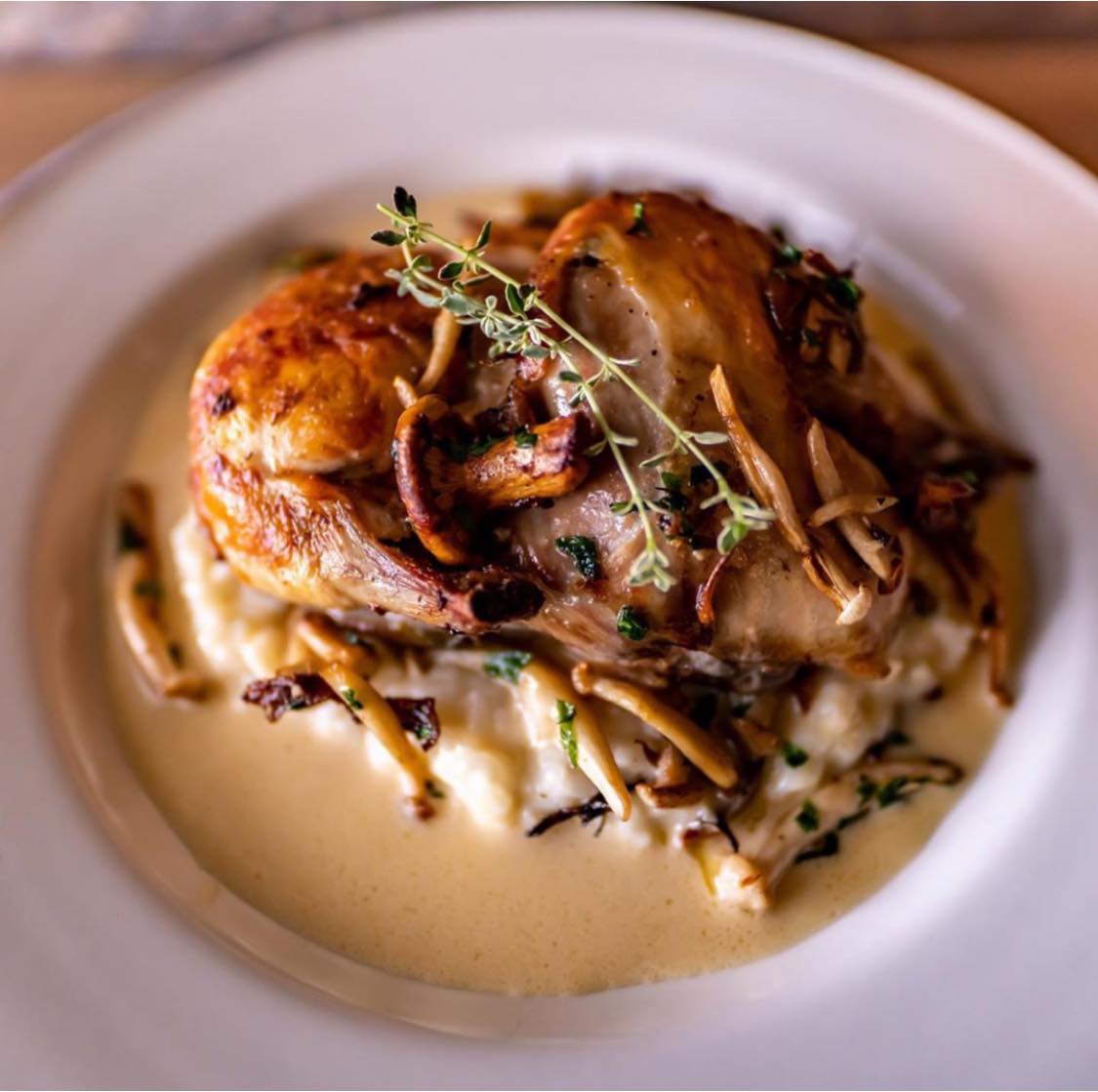 Alberta Farm Chicken, covered in creamy wild mushroom sauce, topped with fresh thyme